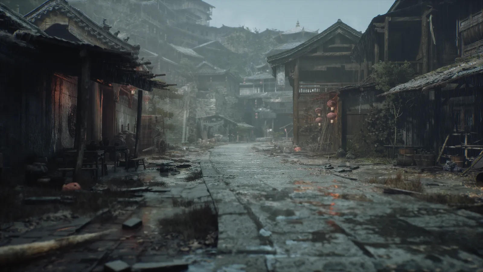 Wet stone road leading into a terraced hillside town of timber buildings with red lanterns in rain.