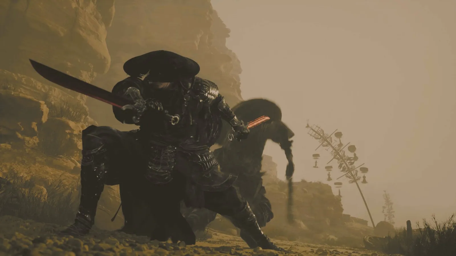 The straw-hat swordsman crouches low in a sandy canyon with a long black blade drawn, a dark figure and a wind-chime pole behind him.