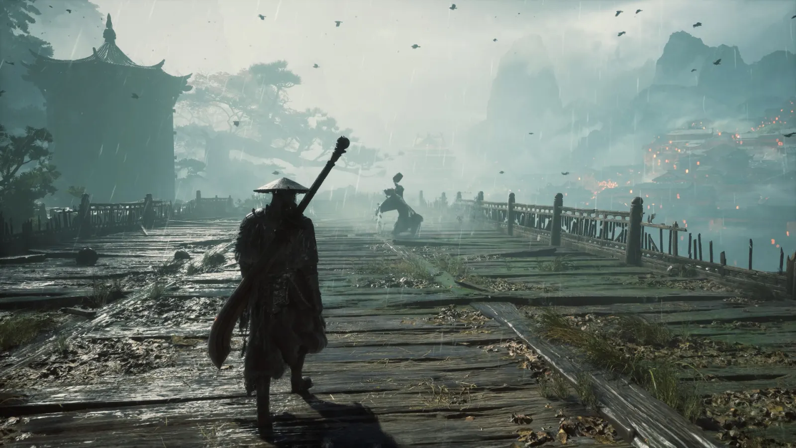 The straw-hat swordsman walks a rain-soaked broken bridge toward a lantern-lit village in misty mountains.