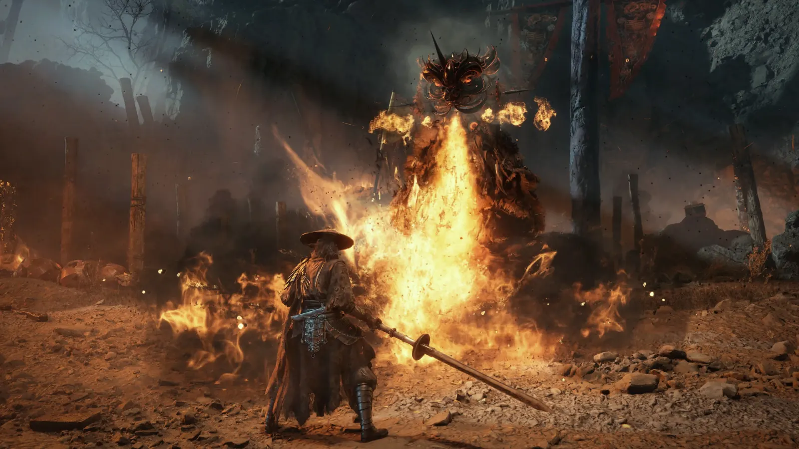 The swordsman stands before a horned, masked giant erupting in a column of fire amid burning stakes and smoke.